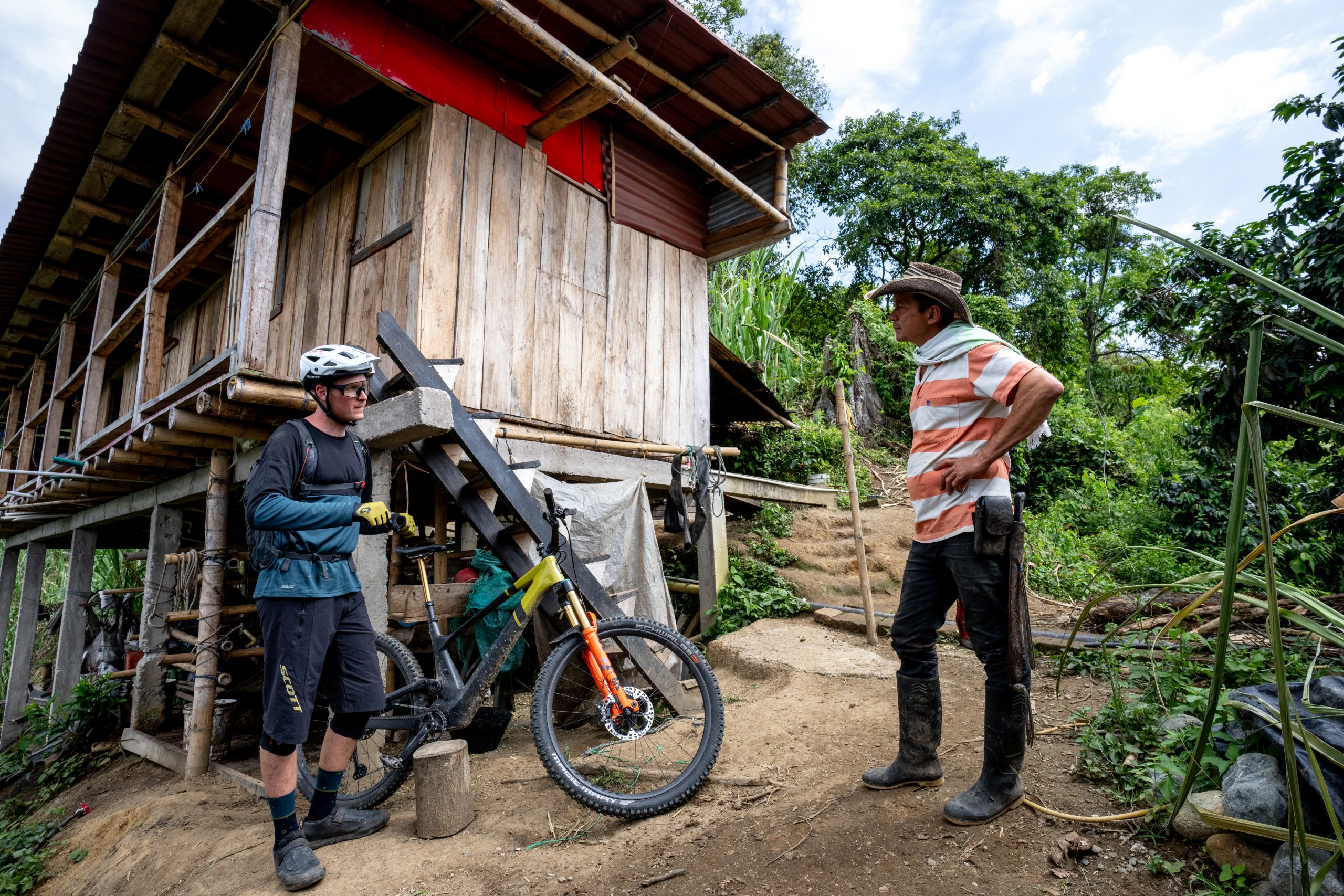 Scotty Laughland explores a rural area in Colombia by mountain bike, engaging with a local. Discover the authentic taste of Colombia adventure. Mountain Bike United.