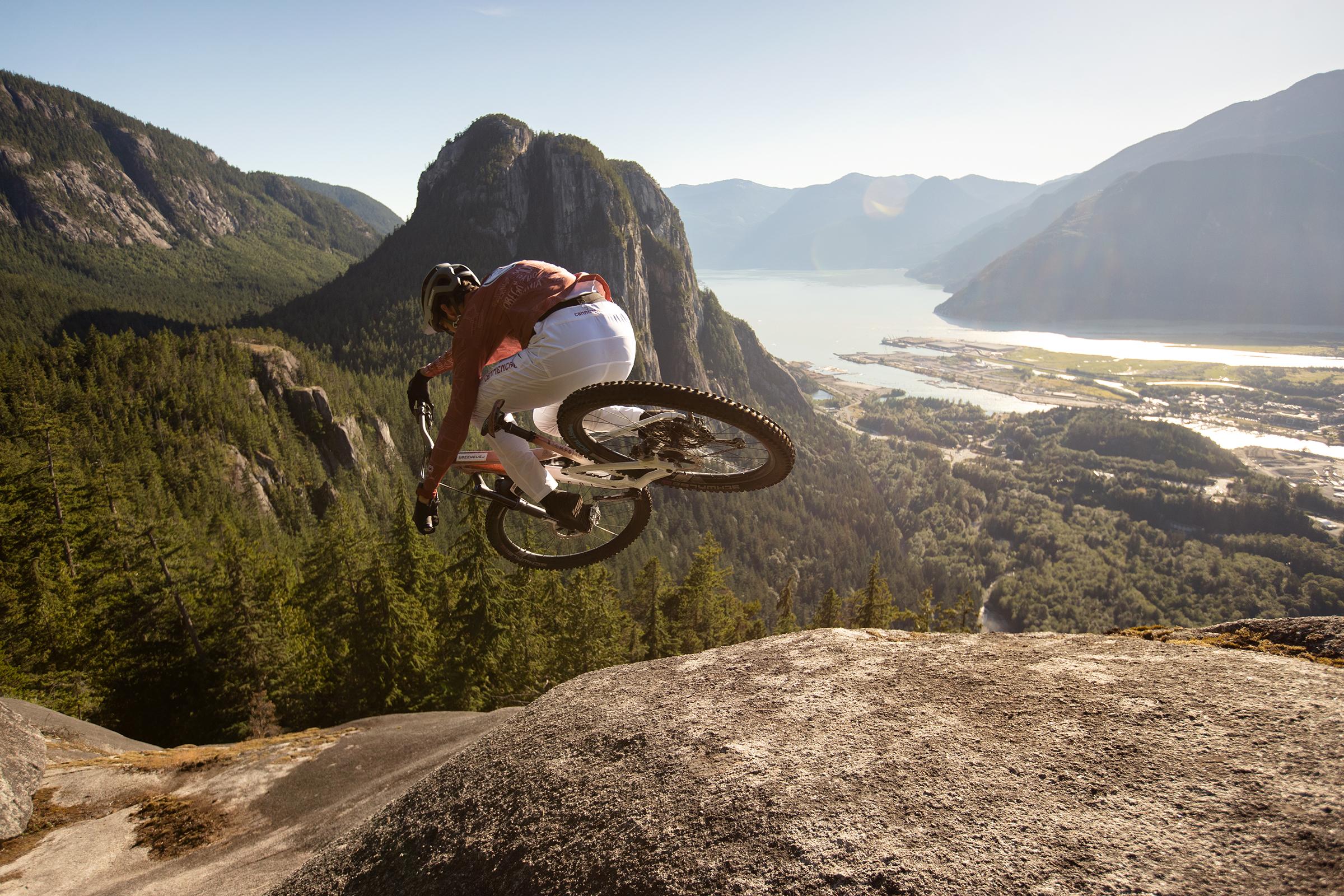 Mountain biker performing a jump in stunning landscape, showcasing Cross Countries skills. Kilian Bron style, extreme mountain biking action. Mountain Bike United.