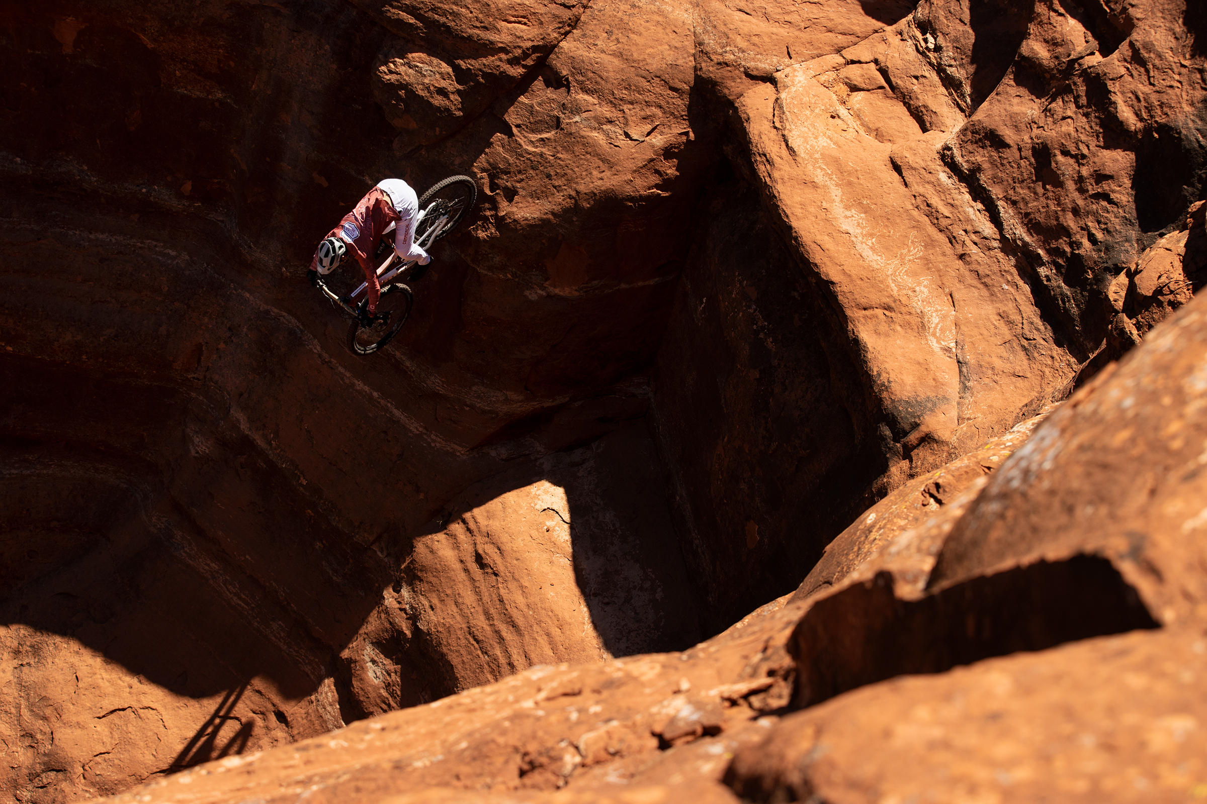 Kilian Bron performs a mountain bike stunt in rocky terrain, showcasing extreme cross-country cycling skills. Mountain Bike United.
