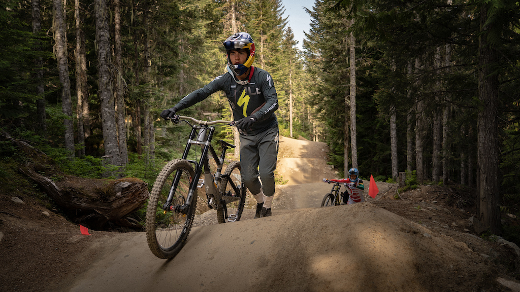 Mountain biker navigating trail, showcasing Finn Iles Swapping Lines technique, surrounded by forest terrain. Mountain Bike United.