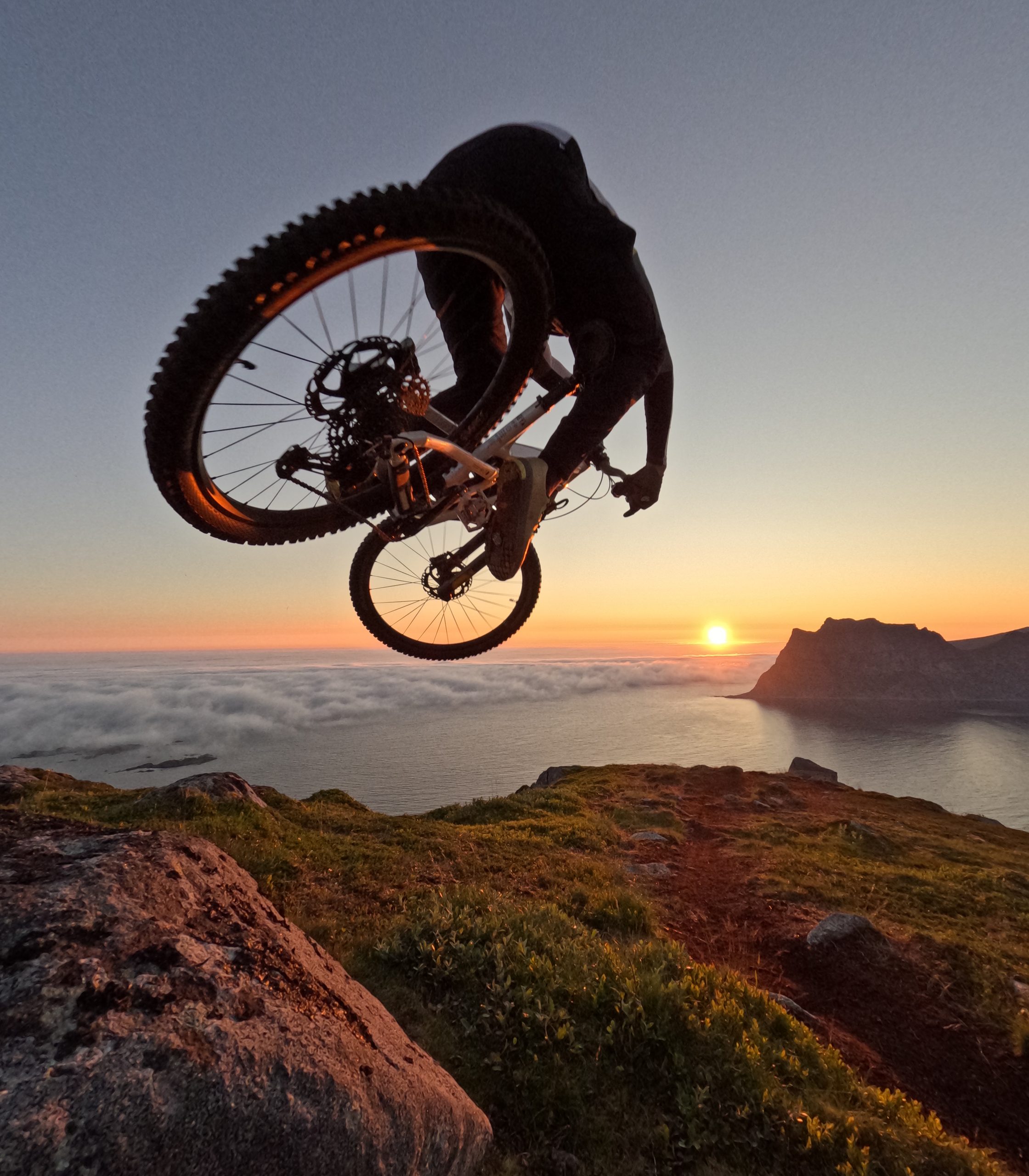 Mountain biker jumping at sunset over scenic coastline, capturing adventure sports, biking action, and nature landscape. Perfect for outdoor and travel content. Mountain Bike United.