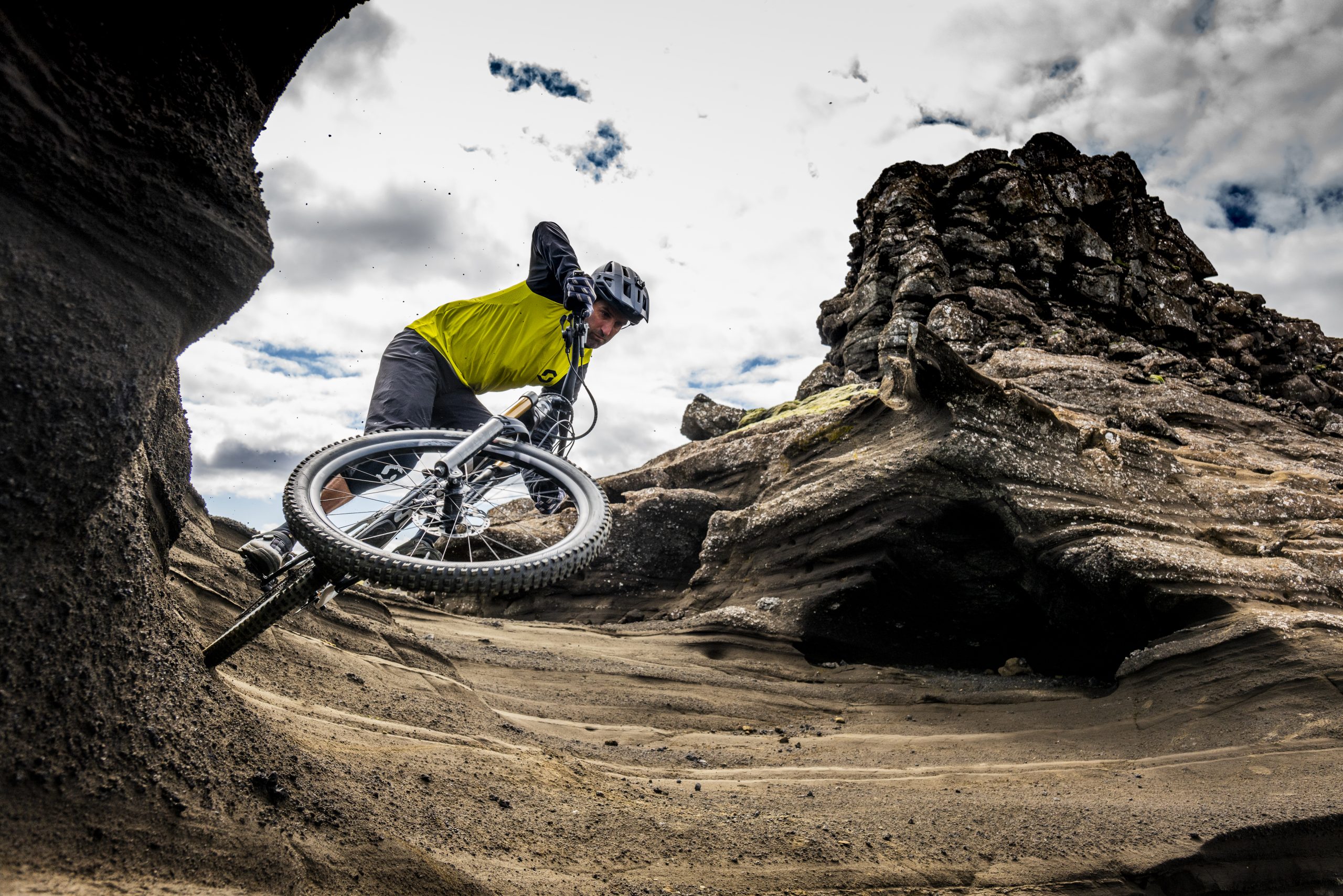 Mountain biker navigating rocky terrain, inspired by Andrew Neethling's Journey to The Centre of The Earth, enhancing extreme biking imagery. Mountain Bike United.