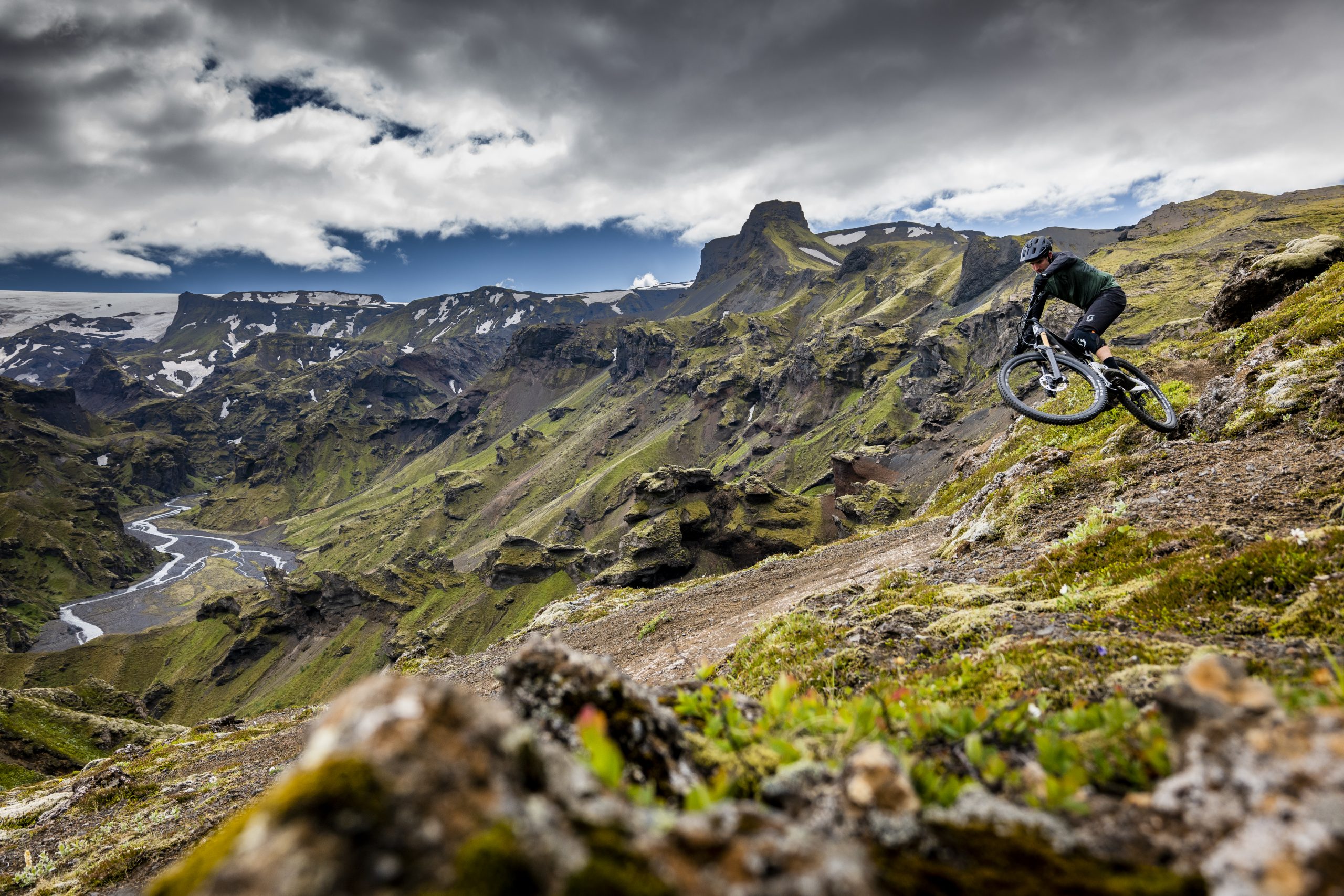 Mountain biker descends rugged terrain, showcasing Andrew Neethling's Journey to The Centre of The Earth adventure in stunning landscapes. Mountain Bike United.