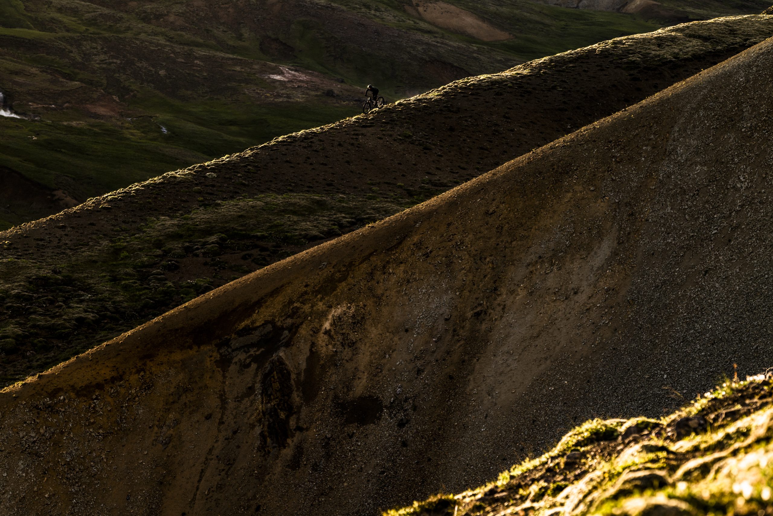 Cyclist on a rugged mountain trail at sunset, capturing the adventurous spirit of Andrew Neethling's Journey to The Centre of The Earth. Mountain Bike United.