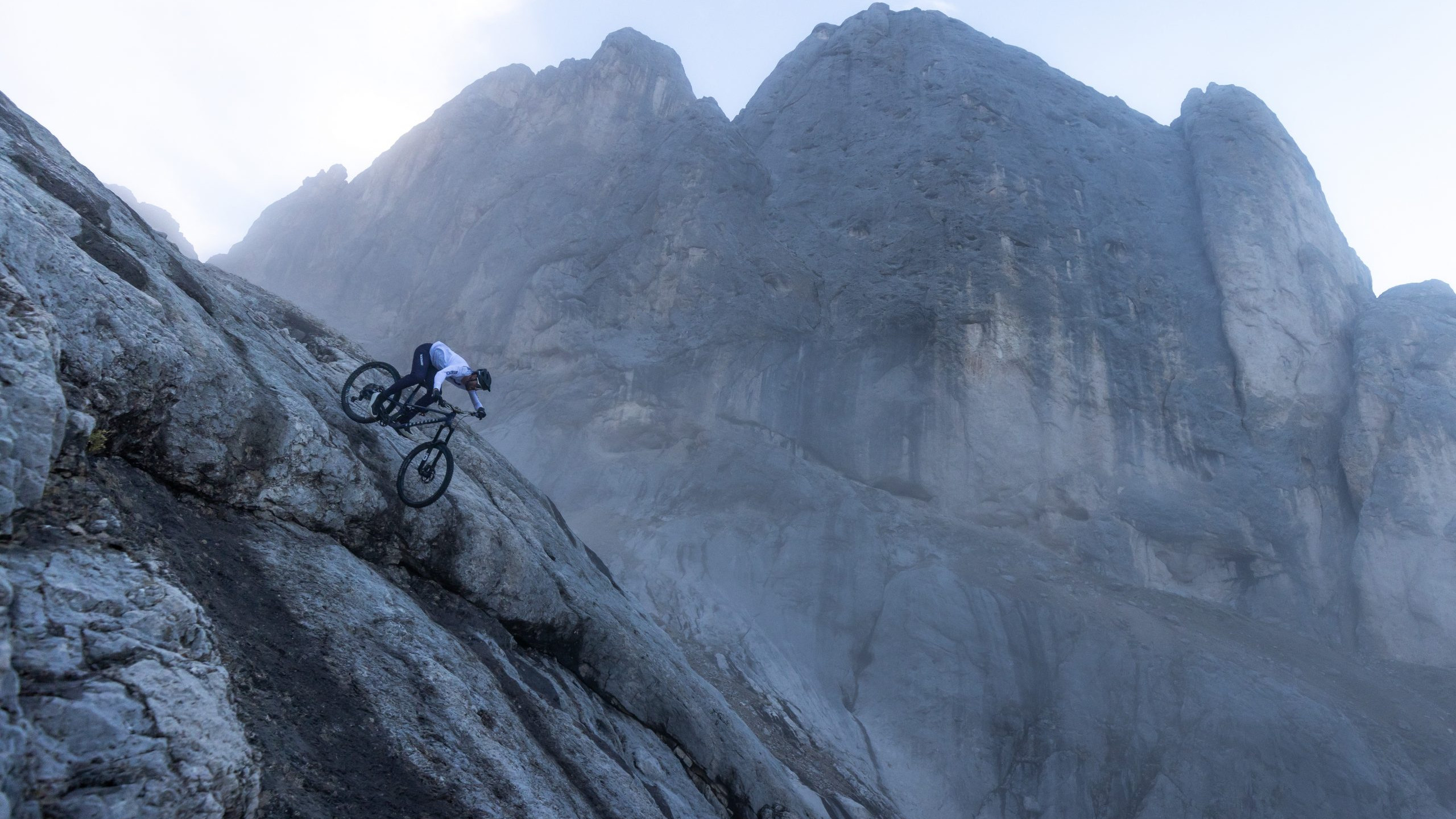 Mountain biker on a steep trail in the Dolomites, showcasing thrilling downhill action, possibly related to Kilian Bron's adventures. Mountain Bike United.