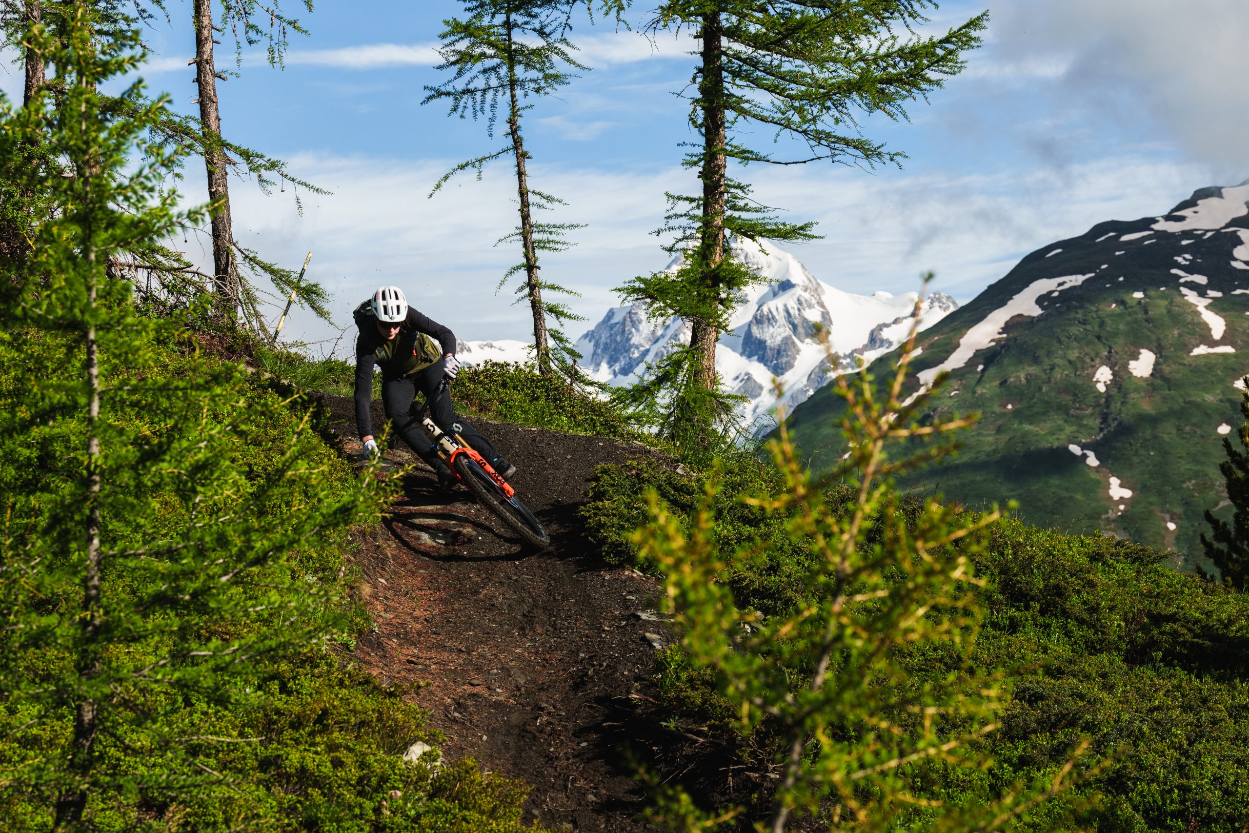Mountain biker on a trail with Alpine views in Italy, showcasing thrilling adventure; ideal for keywords Scotty Laughland Italy mountain biking. Mountain Bike United.