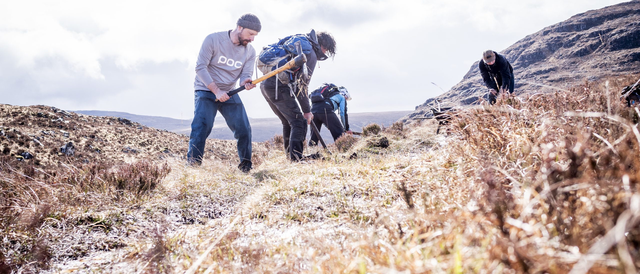 Volunteers planting trees on a hillside, focusing on conservation and reforestation efforts in a natural landscape. Mountain Bike United.