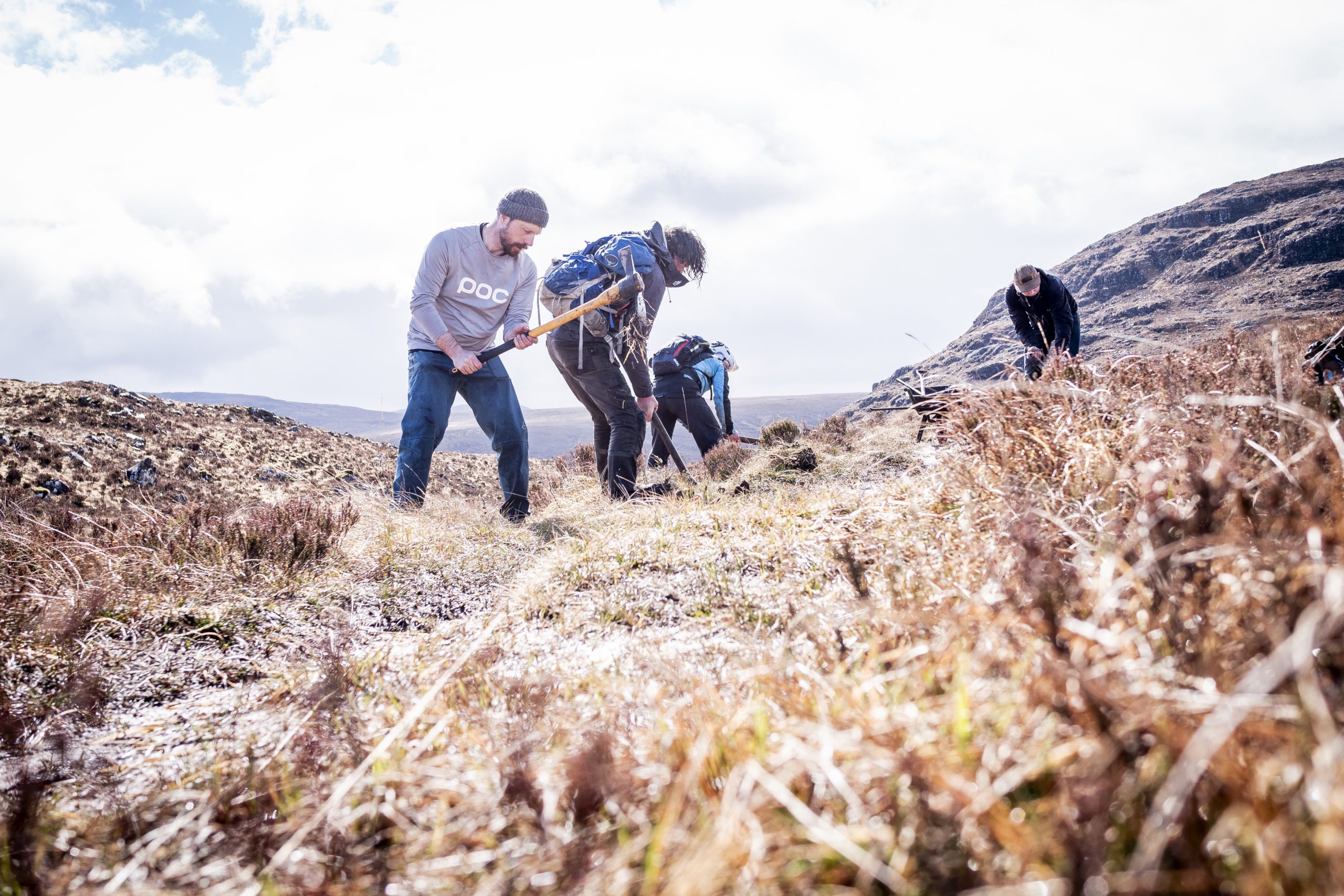 Volunteers planting trees on a hillside, focusing on conservation and reforestation efforts in a natural landscape. Mountain Bike United.