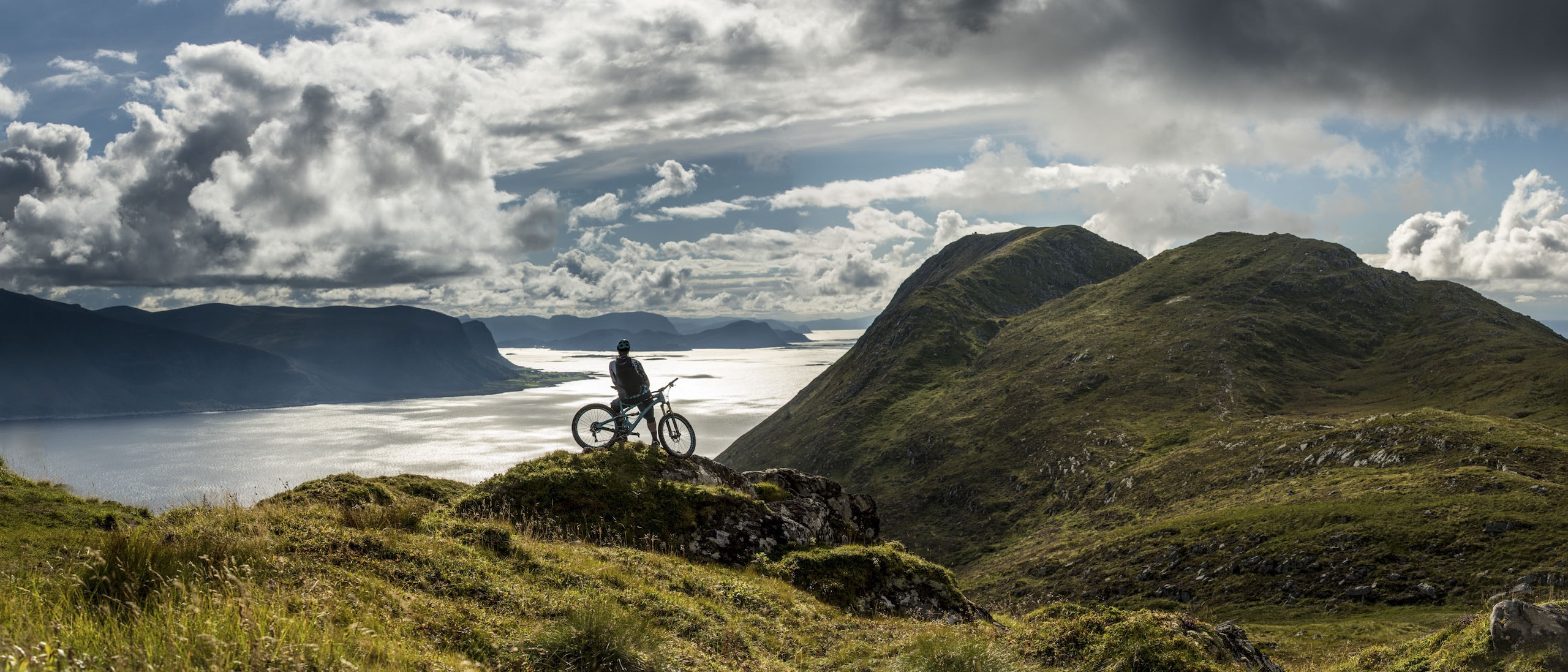 Mountain biker on a scenic trail overlooking a vast landscape; find mountain bike trails for adventure and exploration. Mountain Bike United app. Find mountain bike trails. Plan and share rides. Discover and join events and races. Record your rides directly in app. Strava mountain bike.