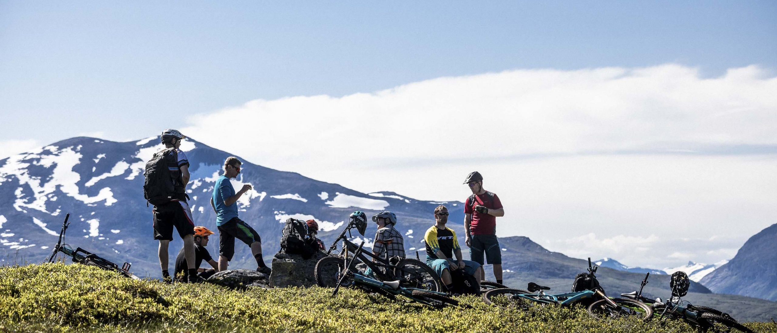 Mountain bikers resting on a scenic trail, showcasing community and adventure. Mountain Bike United.