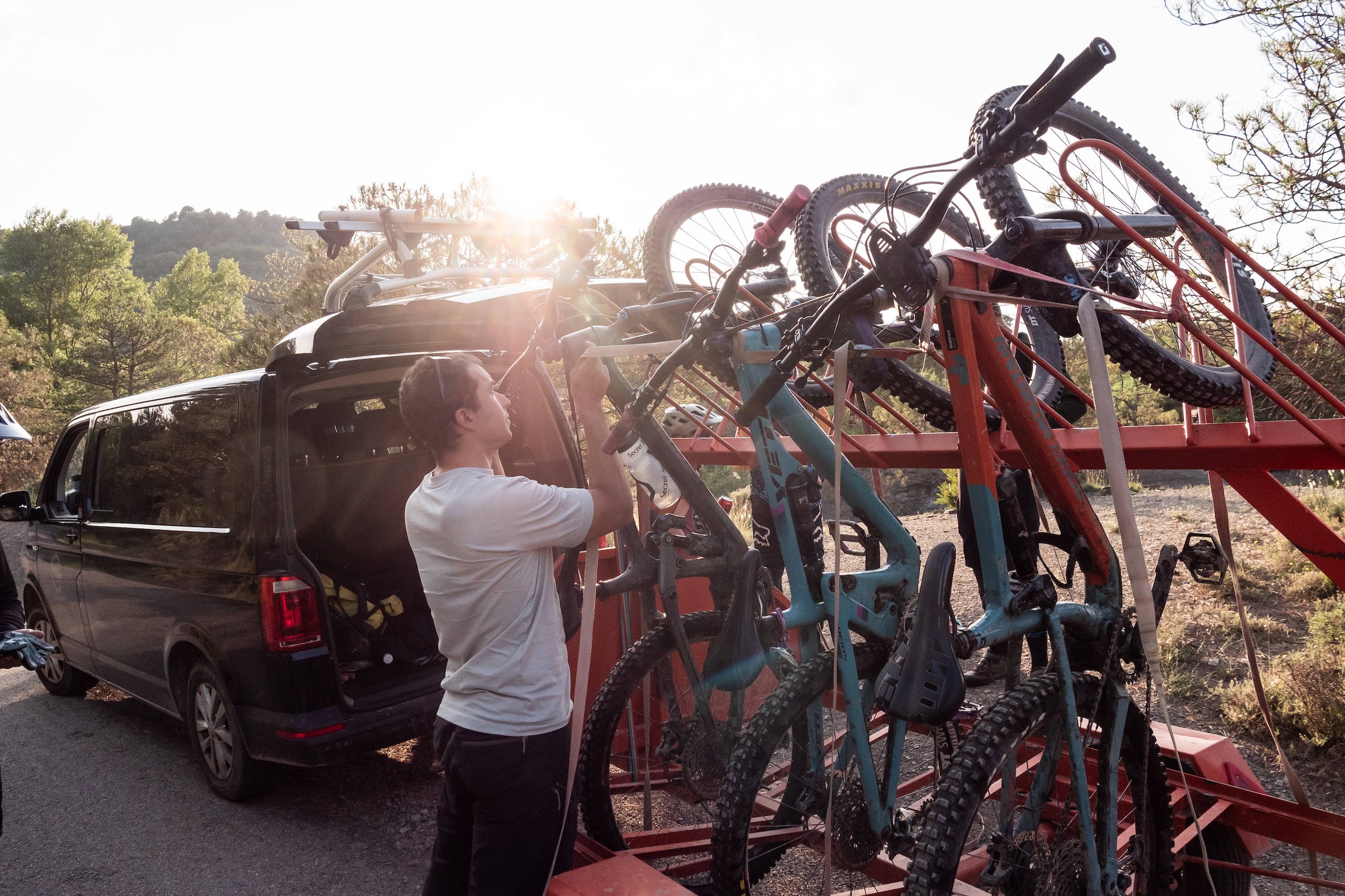 Man loading mountain bikes on a van rack, highlighting the mountain bike community app for connecting enthusiasts and organizing biking adventures. Mountain Bike United.