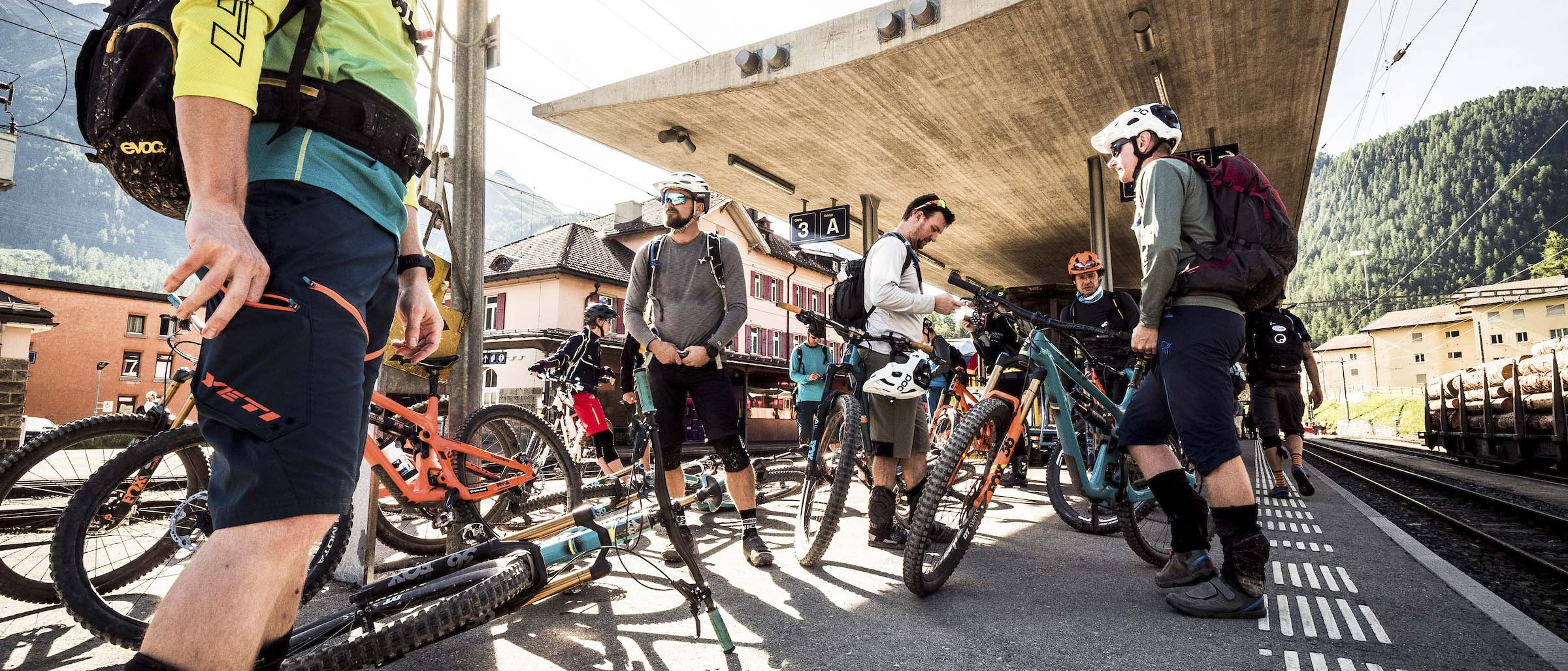 Mountain bike enthusiasts gather at a train station, preparing for an MTB event. Organise MTB event with riders and bikes for outdoor adventure. Mountain Bike United. Organise MTB event. Organising MTB race. Organise MTB festival. Plan and promote MTB event. Plan and promote MTB race.