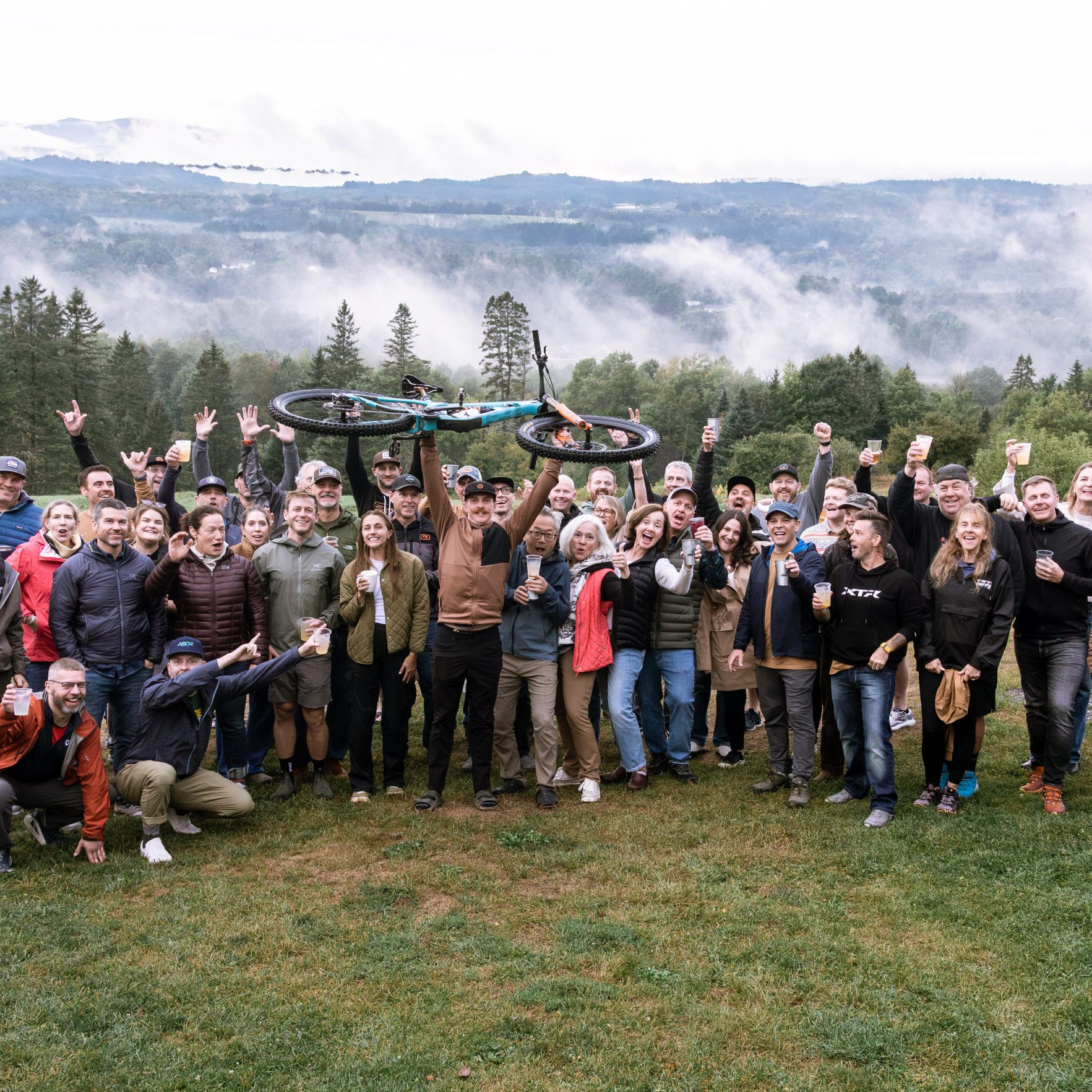 Group of people celebrating at an MTB event in a scenic landscape, perfect spot to organize MTB events successfully. Mountain Bike United.