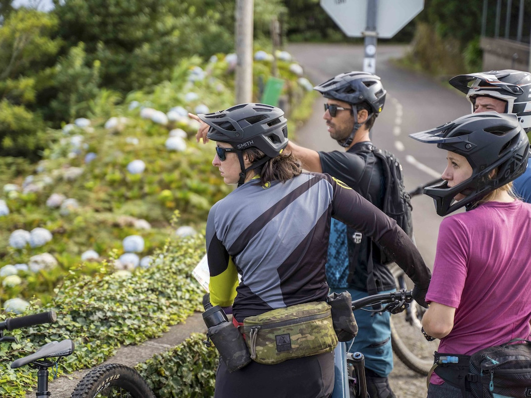 Group of male and female mountain bikers looking at a view