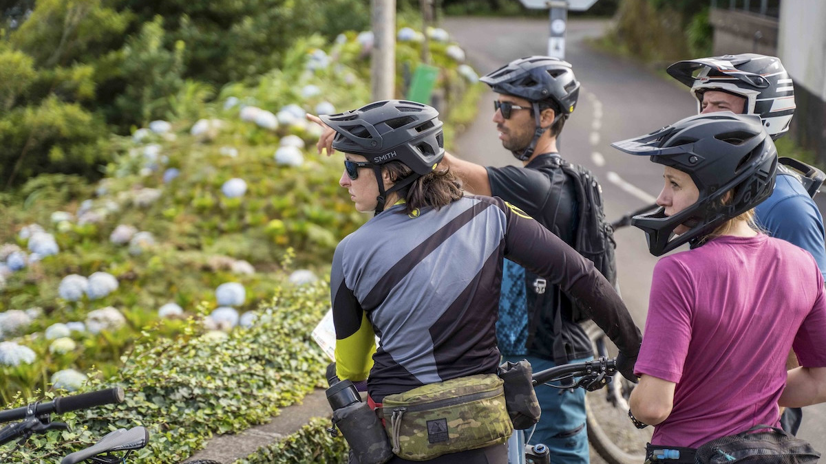 Group of male and female mountain bikers looking at a view