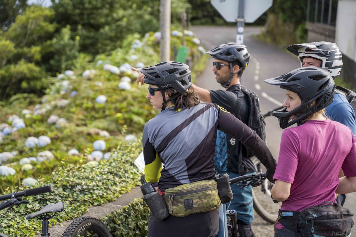 Group of male and female mountain bikers looking at a view