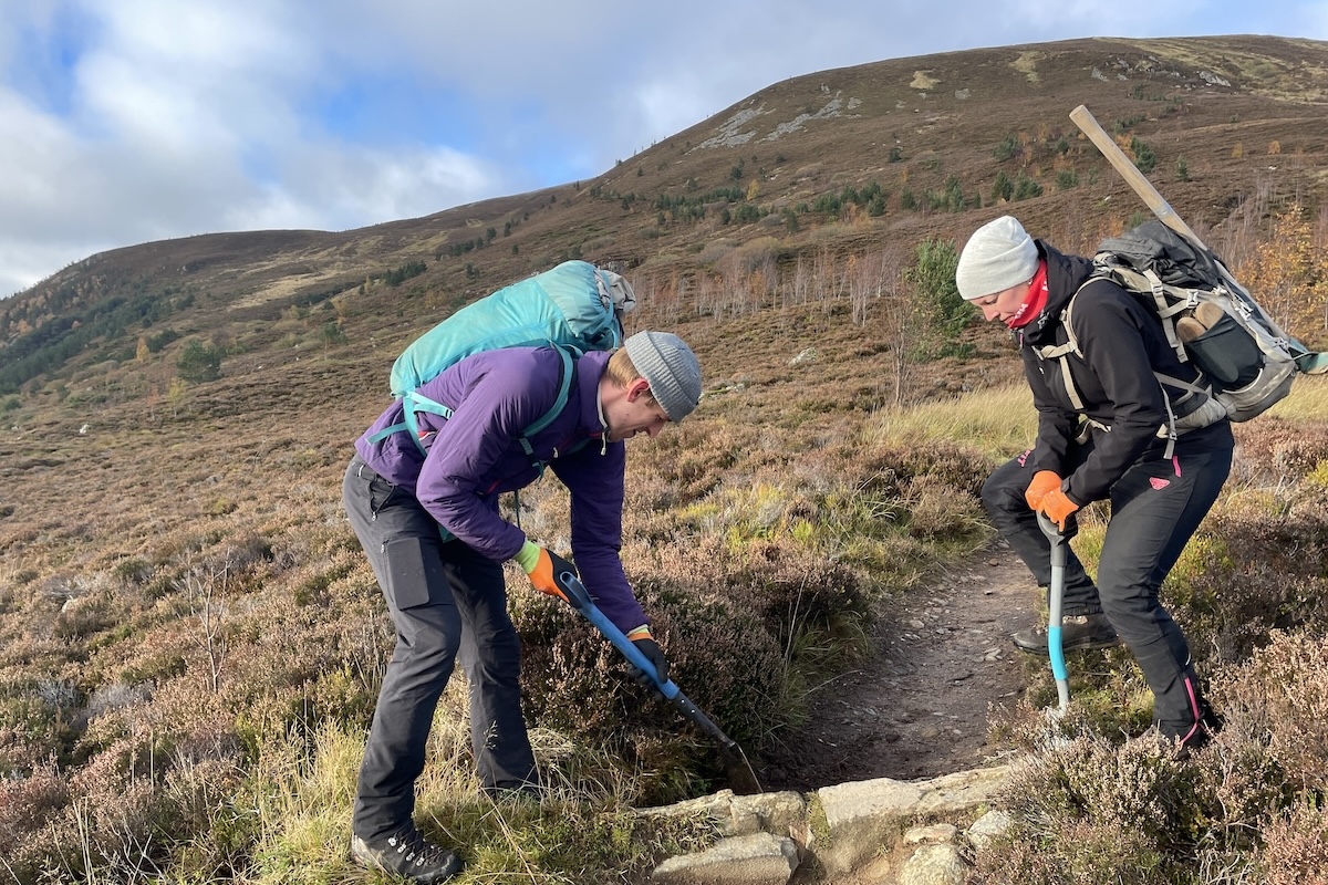 Mountain bike community repairing trail on hillside. Mountain Bike United.