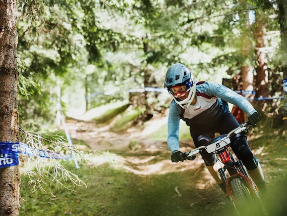 Female mountain biker racing in the Dolomites, Italy. Mountain Bike United.