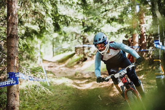 Female mountain biker racing in the Dolomites, Italy. Mountain Bike United.